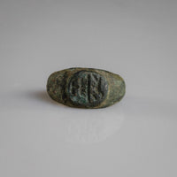 Roman bronze signet ring Numerius with oval bezel showing bird above vessel motif