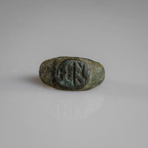 Roman bronze signet ring Numerius with oval bezel showing bird above vessel motif