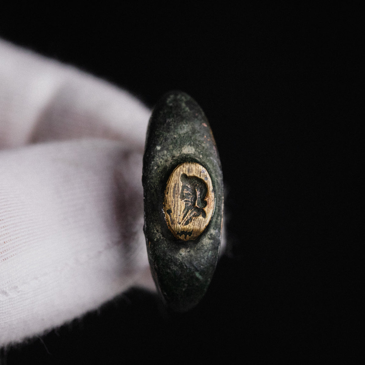 Roman bronze ring Vultinus, close view of the worn engraved profile bust on the bezel