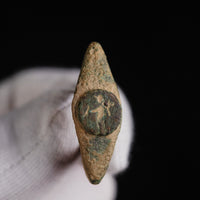 Roman bronze ring Verecundus held in a gloved hand, front view of the standing figure on the bezel