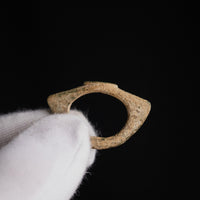 Roman bronze ring Verecundus held in a gloved hand, side profile of the hoop and flaring shoulders