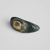 Roman bronze ring Vultinus, angled view of the oval bezel with engraved profile bust and green patina