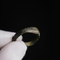 Roman bronze ring Vindex held in a gloved hand, showing the ladder-pattern panel on one sloping face