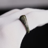 Roman bronze ring Vindex on a gloved finger, with the hatched panel of the head in view