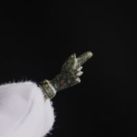 Roman bronze hand pendant 'Manicula' in profile with its long fica thumb, held between gloved fingers