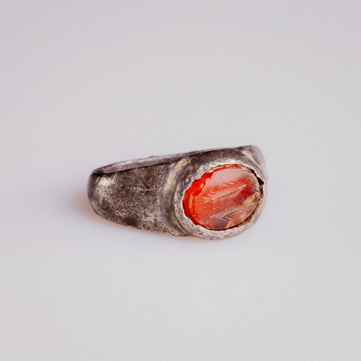 Roman silver ring Pisculus showing carnelian bezel and tarnished shoulders