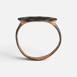 Byzantine bronze ring 'Okellina' shows its complete hoop and the thin oval bezel edge in profile.