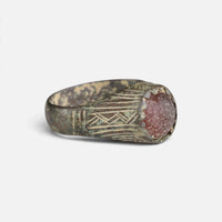 Medieval bronze ring 'Radwina' shows its round setting and engraved broad shoulder at an angle.