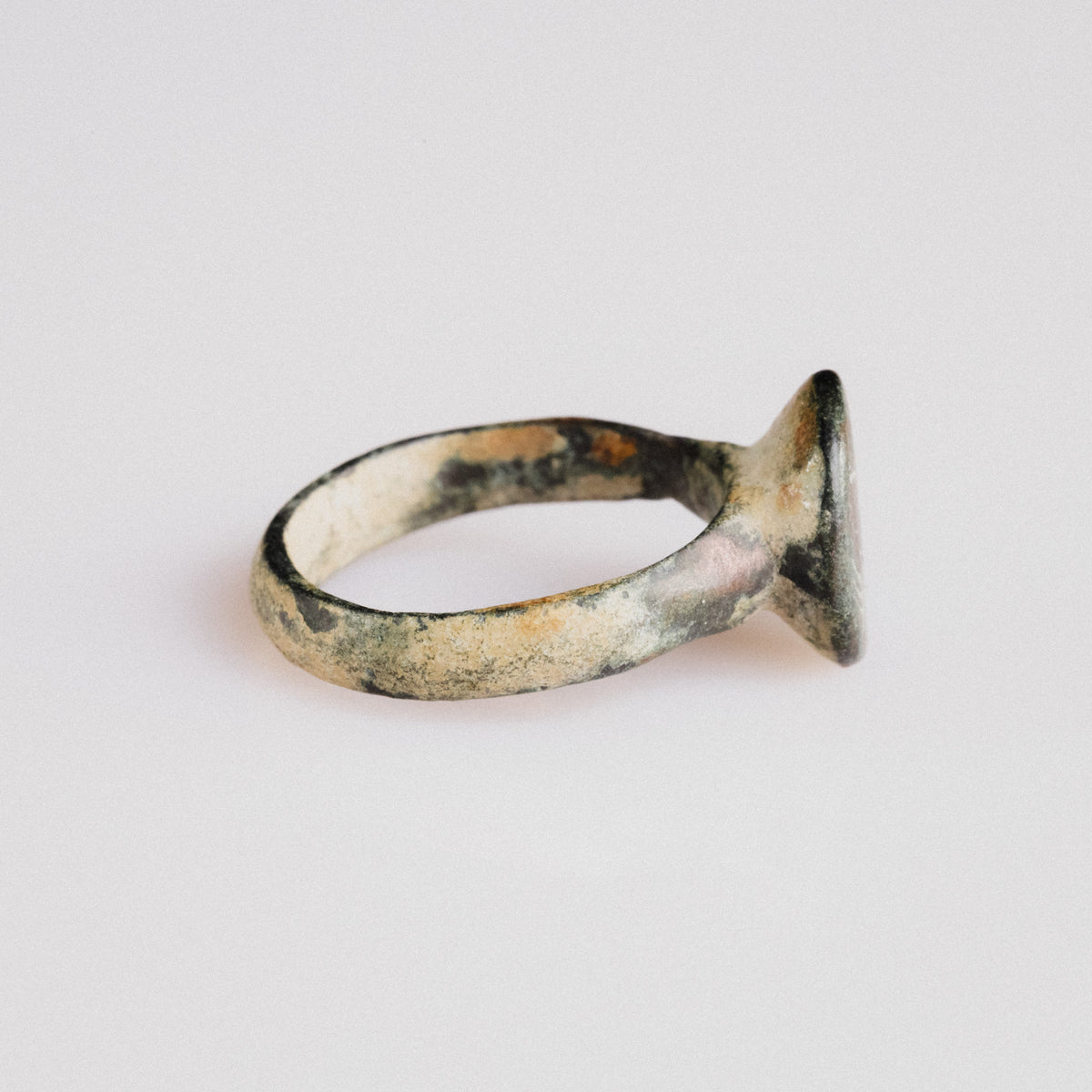Side profile of medieval bronze ring 'Aldric' revealing integral cast bezel and tapered hoop