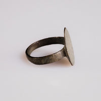 Side profile of medieval bronze ring Rurik showing flat circular bezel and slender band