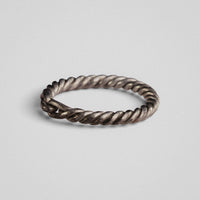 Side profile of medieval silver ring Hravnar with wear-brightened ridges along the twisted band