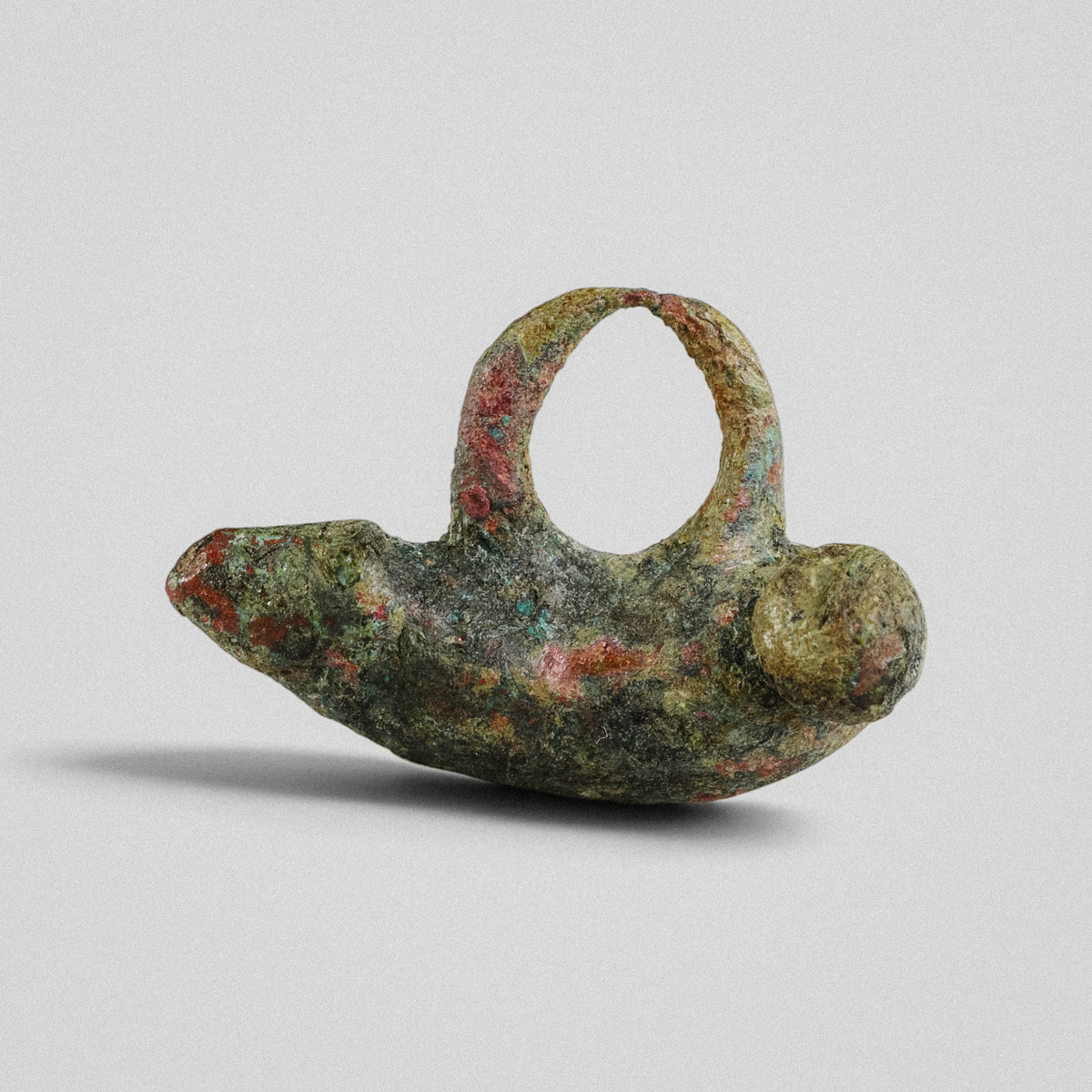 Side profile of Roman bronze pendant 'Felix' showing tapered glans and spherical terminal