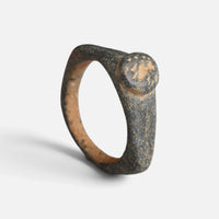 Roman bronze ring 'Aquilarius' shows its circular bezel face and complete broad hoop at an angle.