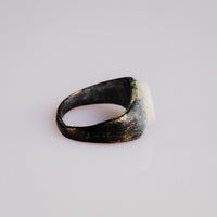 Side profile of Roman bronze ring Numerius revealing D-section hoop and patina