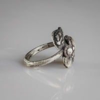 Side profile of Roman silver serpent ring Ophidius with plain round-wire hoop and tarnished patina