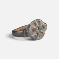 Byzantine bronze ring 'Heliona' shows its pierced circular bezel and broad shoulder at an angle.
