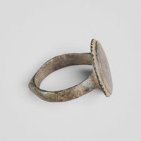 Side view of Byzantine bronze ring Xenaros with flat disc bezel and green patina