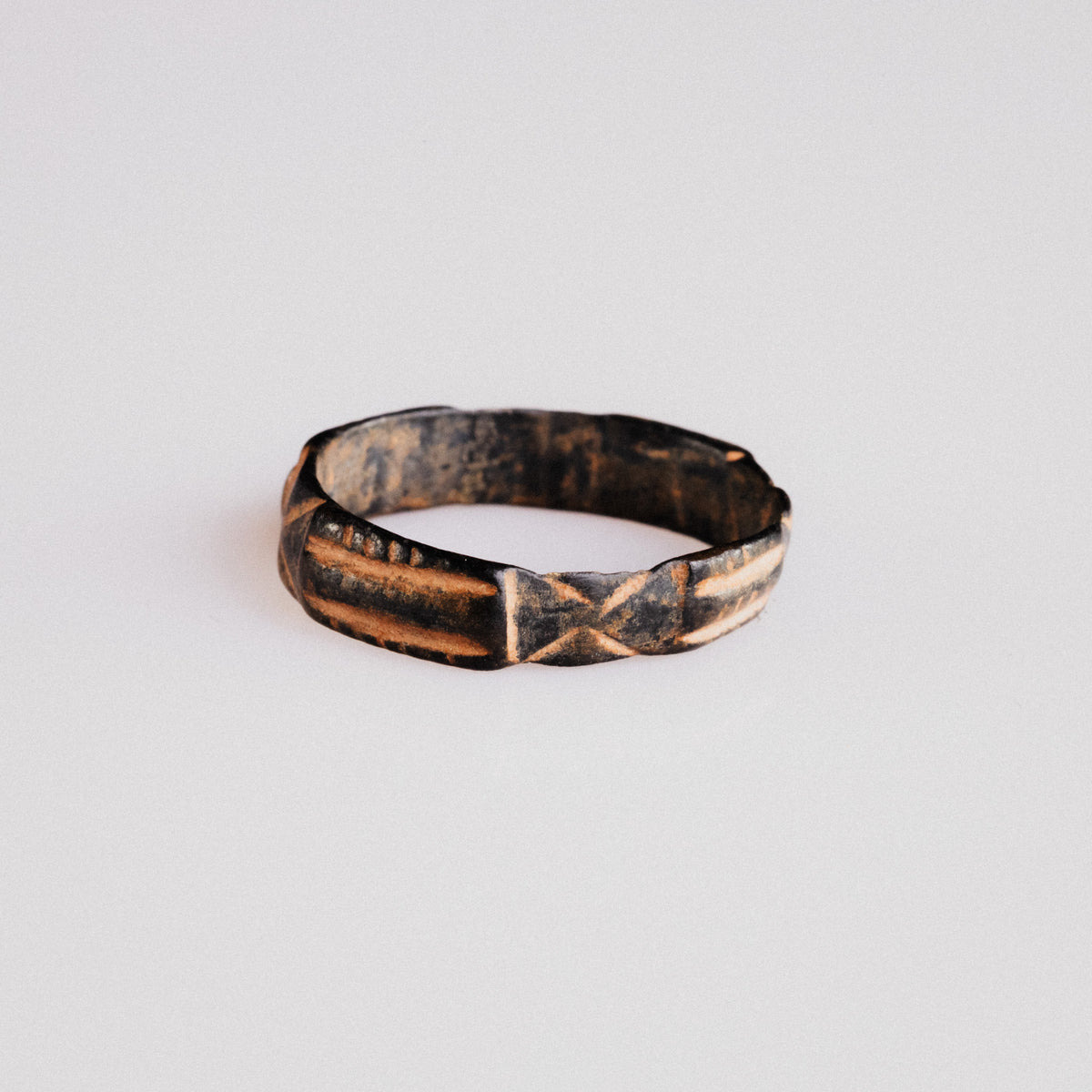 Side view of medieval bronze ring Aldric showing D-section profile and geometric frieze