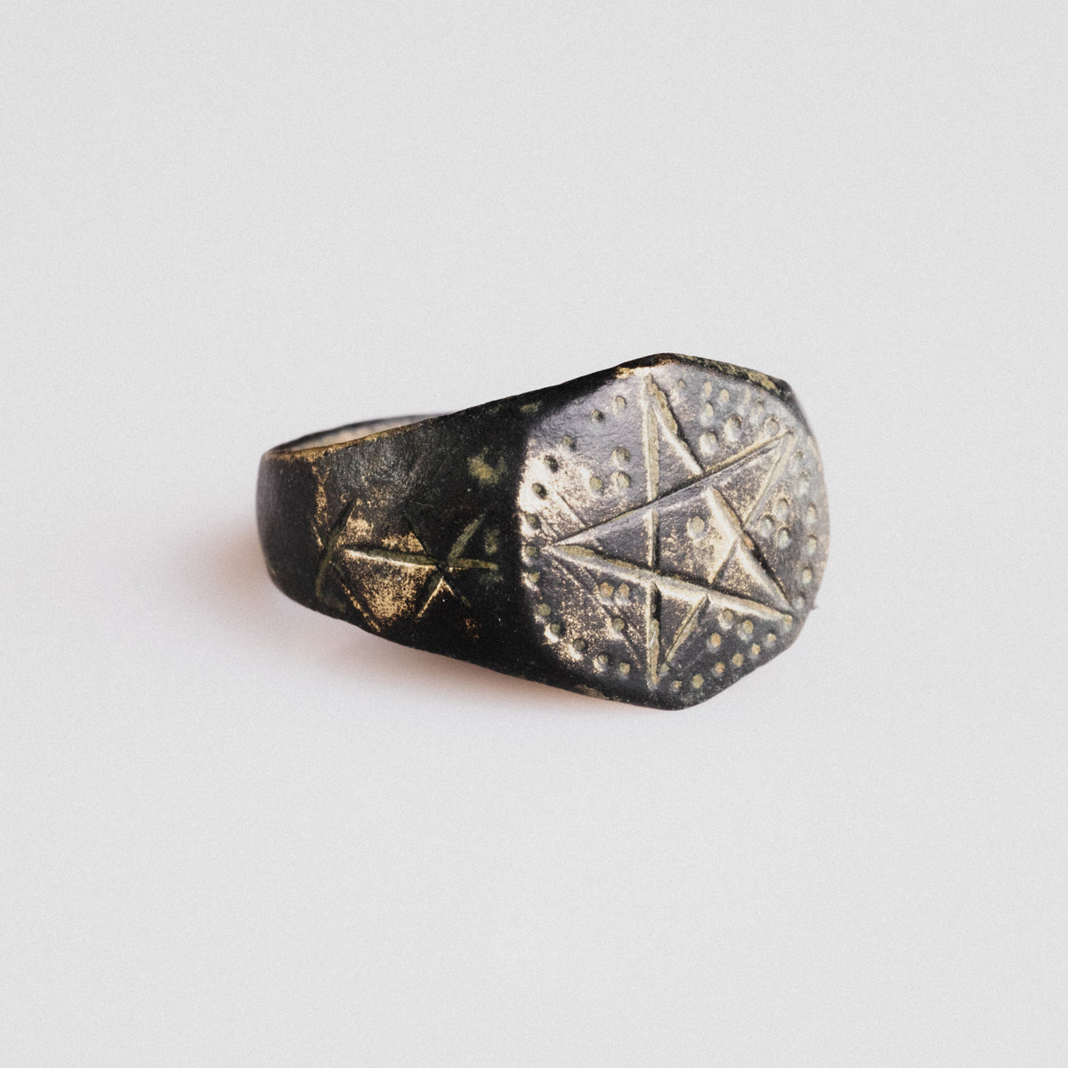 Side view of medieval bronze ring Astariel showing six-pointed star shoulder motifs