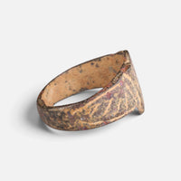 Medieval bronze ring 'Radbert' shows its engraved shoulder and the inside of its hoop from the side.