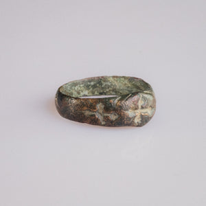 Side view of medieval bronze ring Radenko showing shoulder cross and green patina.