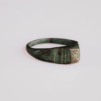 Side view of Roman bronze ring Numerius showing grooved shoulders and green patina