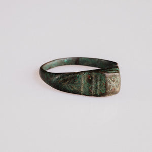 Side view of Roman bronze ring Numerius showing grooved shoulders and green patina