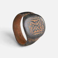 Byzantine bronze ring 'Kallisto' shows its geometric star device and complete broad hoop at an angle.