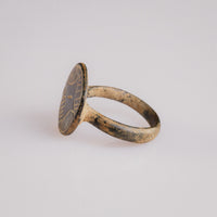Three-quarter view of medieval bronze ring Aldric with hatched geometric engraving