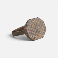 Medieval bronze ring 'Anselm' shows its engraved octagonal bezel and narrow shoulder at an angle.