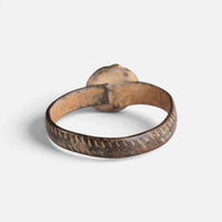 Medieval bronze ring 'Luminara' shows the back of its setting and the inside of the decorated hoop.