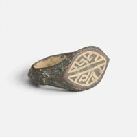 Medieval bronze ring 'Radwin' shows its geometric bezel engraving and broad shoulder at an angle.