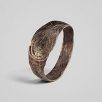 Silver band ring 'Ovata' shows its full hoop and concentric oval engraving at a three-quarter angle.