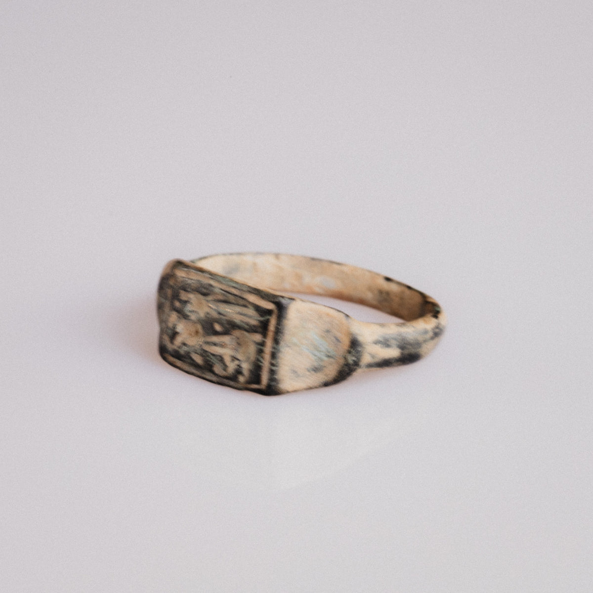 Three-quarter view of Roman bronze ring Grypho with griffin engraving on bezel