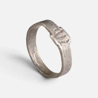 Roman silver ring 'Sextus' shows shallow cuts on its small bezel and the complete hoop at an angle.