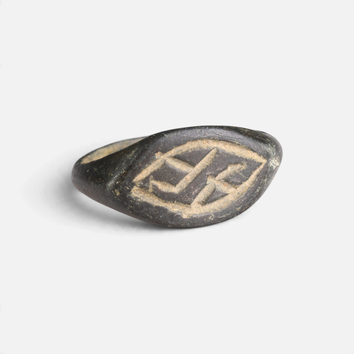 Medieval bronze ring 'Aldhelm' shows the lozenge engraving on its pointed oval bezel from the front.