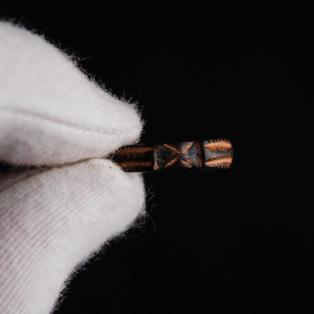 Top-down macro of medieval bronze ring Aldric showing crisp saltire and ladder motifs