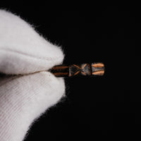 Top-down macro of medieval bronze ring Aldric showing crisp saltire and ladder motifs