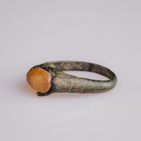 Top-down macro of medieval bronze ring Vukmir cabochon and four claw prongs