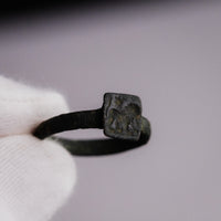 Top-down view of Byzantine bronze ring Zosimos held in gloved hand showing bezel
