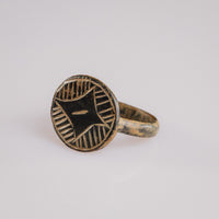 Top-down view of medieval bronze ring Aldric with engraved star motif and quadrant hatching