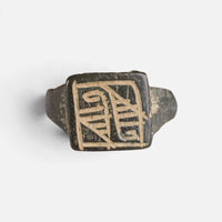 Medieval Islamic bronze ring 'Rashida' shows two registers of angular engraving on its rectangular bezel.