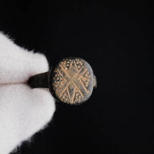 Top view of Byzantine bronze ring Stellaris showing engraved radiating star motif with punched dots