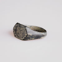Top view of medieval silver ring Radomir with engraved crossed motif and sunburst frame
