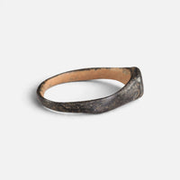 Byzantine bronze ring 'Isidoros' shows its narrow shoulder and the inside of its hoop from the side.