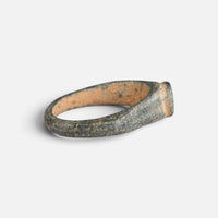 Roman bronze ring 'Aquilarius' shows its inner shoulder and hoop at an angle from behind.